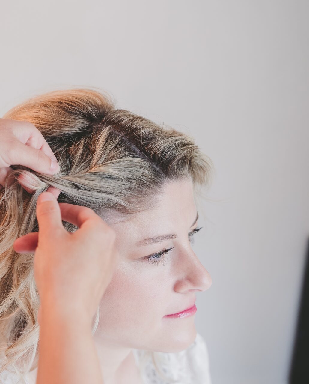 Der Braut wird das Haar für die Hochzeitsfrisur gesteckt